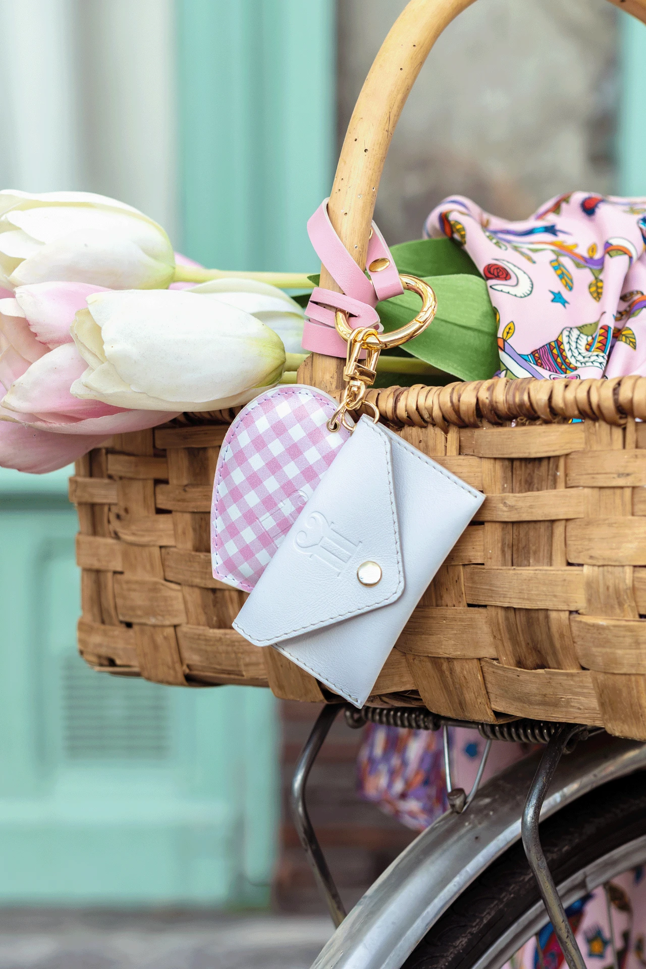 Bijoux de sac vichy rose et enveloppe blanche sur un panier fleuri